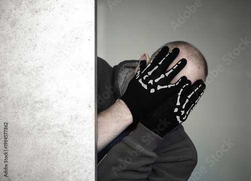 Person Hiding Face With Skeleton Gloves Mystery Concept