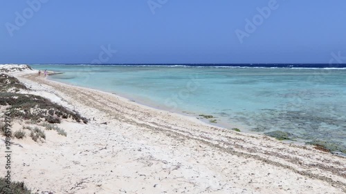 White sand beach in Wadi El Gemal National Park near Marsa Alam, Egypt. Crystal clear water in Red Sea with coral reef and waves