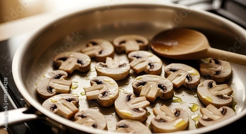Saut ed mushrooms in a pan with wooden spoon culinary preparation