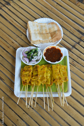 Pork Grilled Satay Skewers served with lime and peanut sauce is a popular street food in Thailand and Asia.