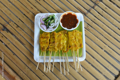 Pork Grilled Satay Skewers served with lime and peanut sauce is a popular street food in Thailand and Asia.