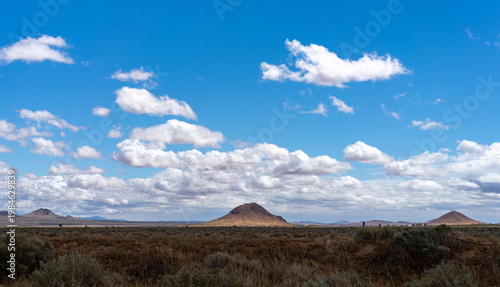 Twin Buttes in the Mojave Desert Beneath Blue Skies and Passing Clouds