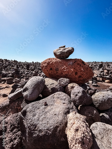 Stone cairns on volcanic beach with ocean waves, Playa del Duque Norte, Tenerife