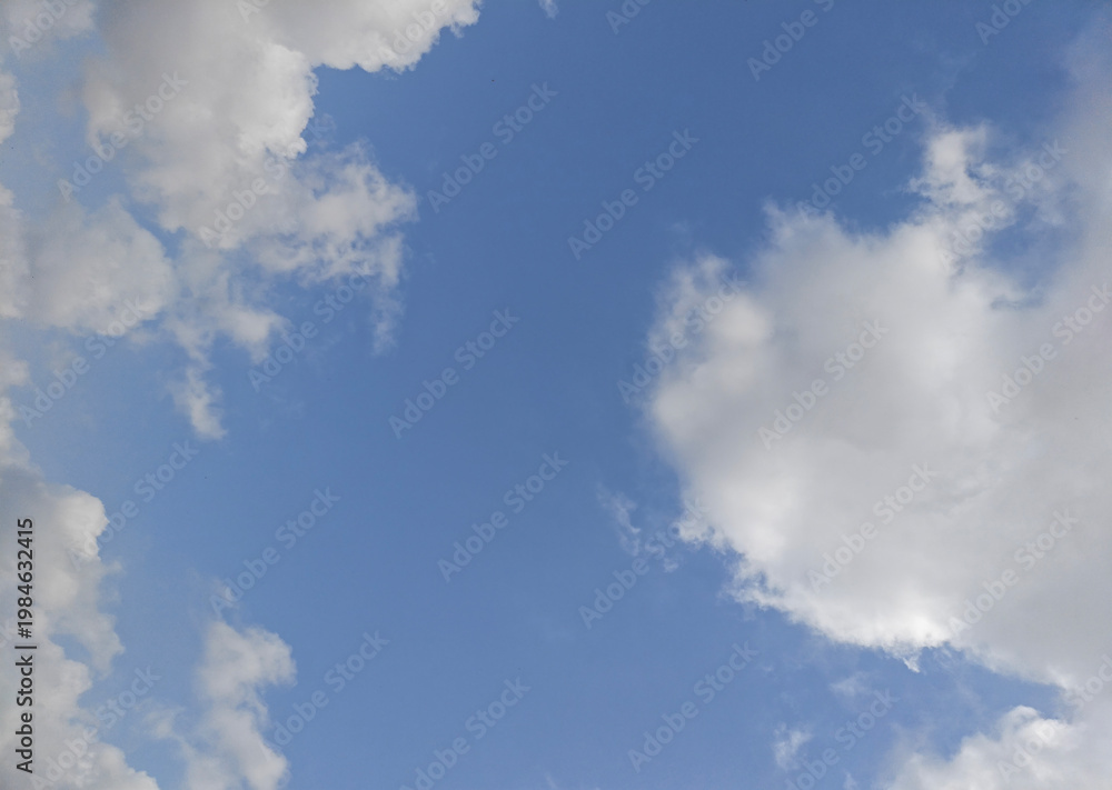 Obraz premium Blue sky with large soft clouds forming natural frame, minimal cloudscape background with open copy space and serene atmosphere
