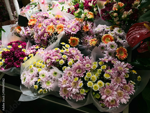 Colorful bouquets of chrysanthemum and gerbera arranged in florist shop. Bright retail display representing decoration, gift idea and floral business concept