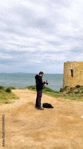Vertical slow motion shot of a photographer reviewing images on camera after taking a photo outdoors