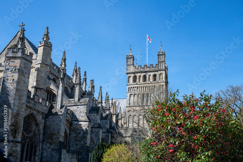 Exeter cathedral in Devon, England. Famous Exeter landmark with a blue sky background and flag flying. Religion and worship. 