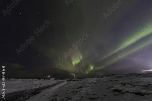 Aurora borealis over lighthouse and geothermal steam wide sky Reykjanes Iceland