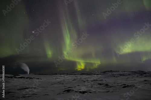 Active aurora borealis over geothermal vent winter Reykjanes Iceland