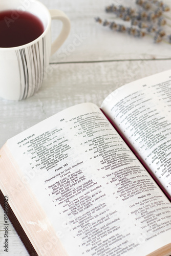 Holy bible book with cup of tea on wooden background. Selective focus. Christian thanksgiving to God Jesus Christ, Scripture study and reading concept.