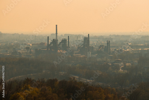Industrial Fog Scene. Heavy Industry Silhouettes Beneath Muted Golden Light And Thick Emissions