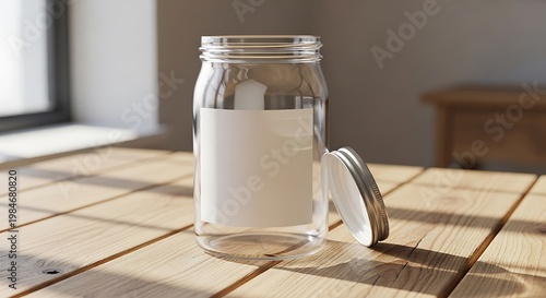 A clear glass jar with a white label sits on a wooden table in bright sunlight