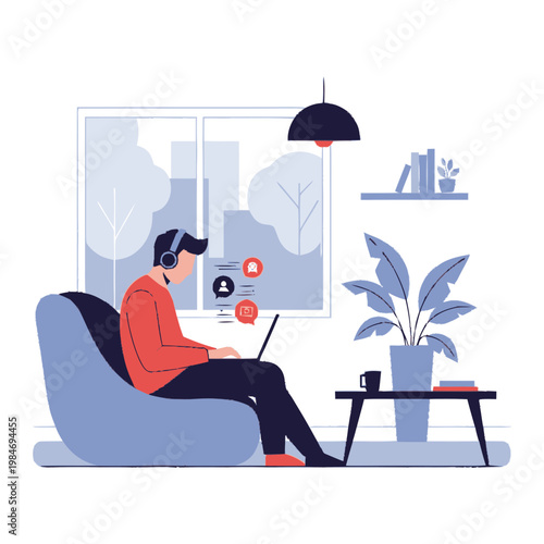 Young man wearing headphones working on a laptop while sitting comfortably in a beanbag chair at home, with a plant and books on a table nearby.