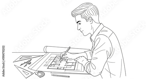 Young man sketching at desk concentrating on drawing.