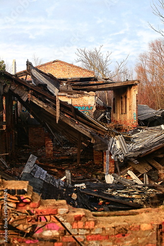 Abandoned brick building with collapsed roof and visible structural damage
