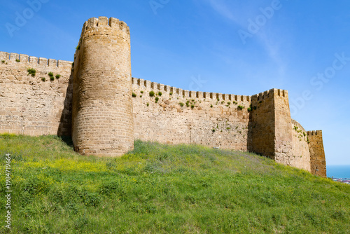 A wall with towers of the ancient fortress of Naryn-Kala on a sunny May day. Derbent, Republic of Dagestan. Russian Federation