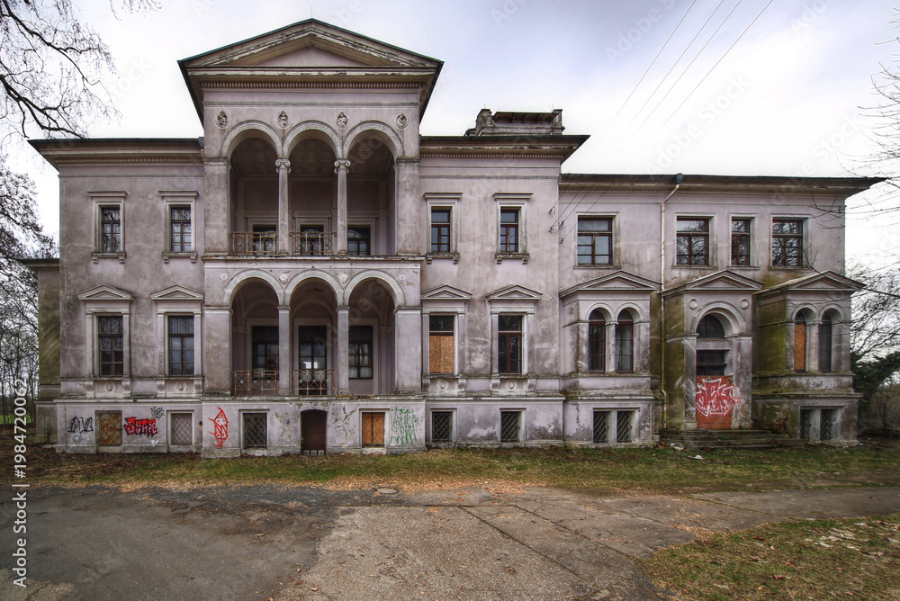 Fototapeta premium Abandoned historic mansion facade of Schloss Randau in Germany with columns boarded windows and graffiti
