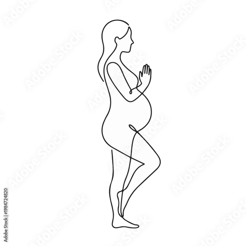 A pregnant woman is practicing yoga and standing in a tree pose while holding her hands together, creating a sense of peace and tranquility
