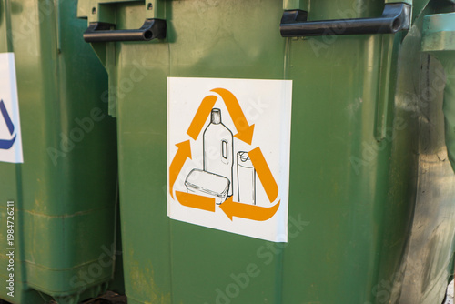 Green recycling bins with recycling symbol showing plastic bottle and containers for sorting waste