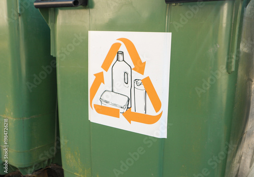 Green recycling bins with recycling symbol showing plastic bottle and containers for sorting waste