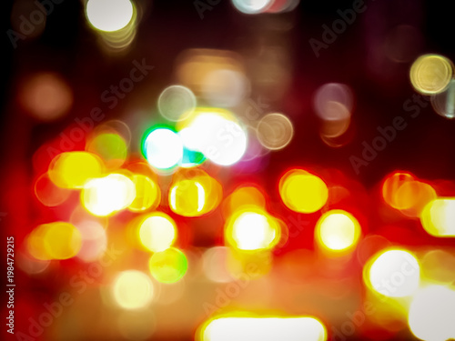 Abstract blurred city lights at night creating colorful bokeh effect, capturing vibrant urban atmosphere with glowing traffic and soft defocused illumination.