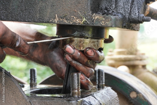 Close up of mechanic hands repairing industrial machine