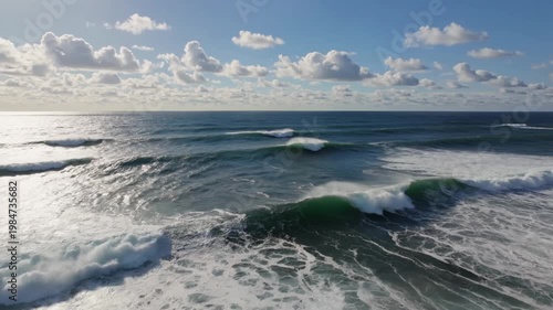 Vast Midday Ocean Beneath Bright White Clouds With Dynamic Swells and Shimmering Reflections Below