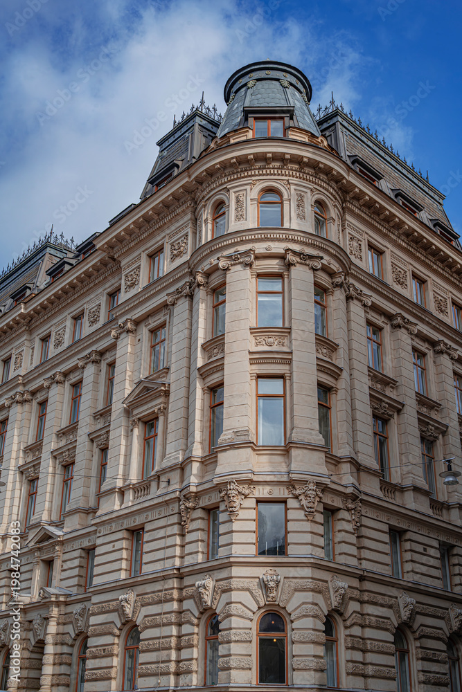 Fototapeta premium a majestic neoclassical corner building in Stockholm featuring ornate stone facades and a dark mansard roof.