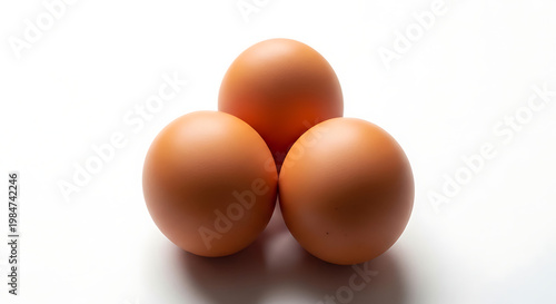 Three brown eggs arranged on a white background with breakfast ingredient isolated nutrition preparation