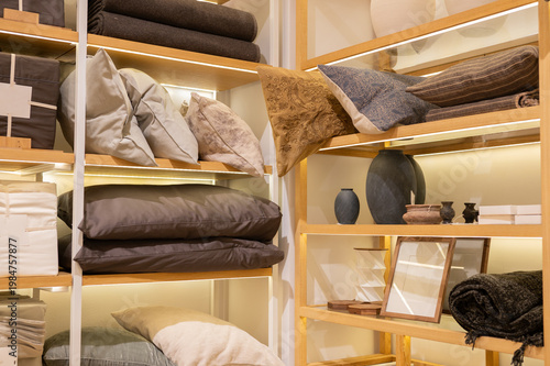 фотографія Stacked bedding and home decor displayed on wooden shelving