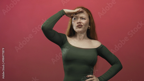 Fotografia Redhead woman hand to forehead shading eyes with exposed shoulder in studio; exasperation pondering