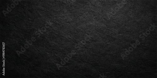 A dark macro shot of a rough black paper texture featuring a grunge pattern on a matte material surface suitable as a sophisticated wallpaper backdrop