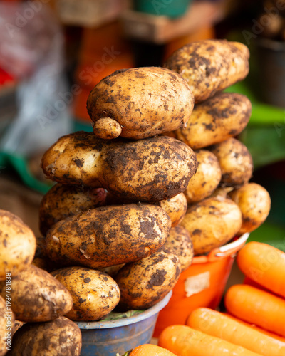Fresh potatoes displayed in buckets at a vibrant Chiapas market stall in San Cristobal de las Casas, Mexico.