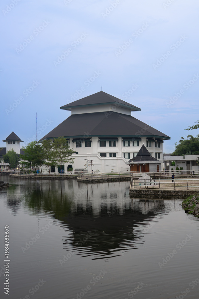 Fototapeta premium Modern Javanese architecture building with water reflection at Embung Giwangan, Yogyakarta