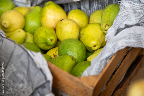 Fresh pears displayed in buckets at a vibrant Mexican market stall in Chiapas, Mexico.