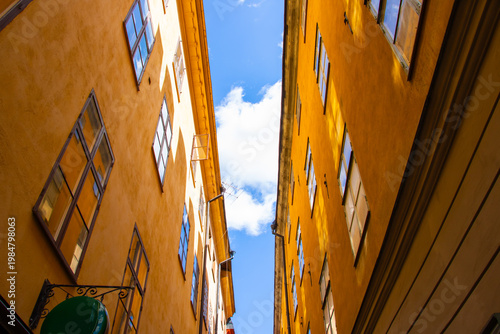 Narrow street in Gamla Stan Stockholm with yellow buildings and blue sky perspective