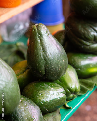 Fresh chayote squash and mint leaves piled together in a vibrant green display in Chiapas, Mexico