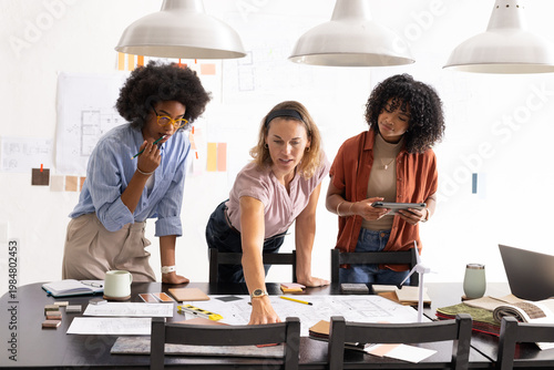 Canvas Print Vertical video: Diverse female colleagues pointing at blueprints after client fe