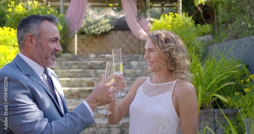 Four friends celebrating, couple hugging, kissing cheek and toasting with flutes at base of steps