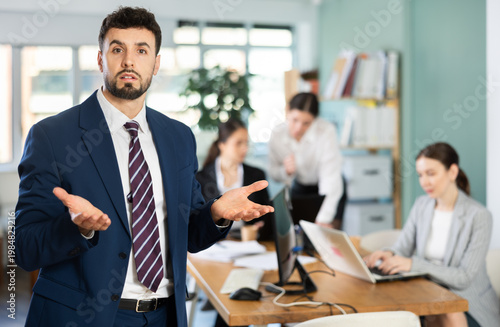 Fotografi Confused young man posing while working in office space