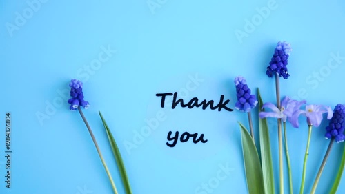 minimal floral composition with thank you text and blue blossoms
