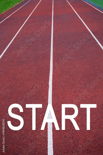 Red running track with white lines and large START word, sports motivation, competition beginning, athletics goal, active lifestyle.