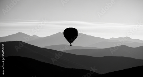 Hot Air Balloon Silhouette Over Mountain Layers.