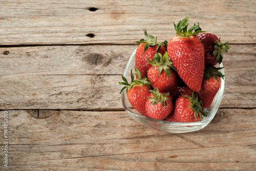 Fresh Strawberries in a Glass Bowl on a Wooden Table