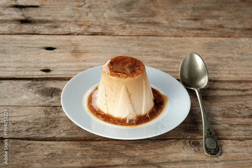 Delicious Panna Cotta Served on a Simple Plate With a Spoon Nearby