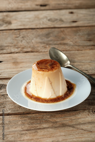 Delicious Panna Cotta Served on a Simple Plate With a Spoon Nearby