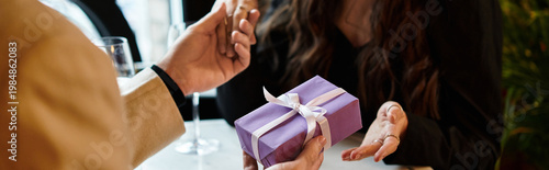 Cuadro en lienzo Couple celebrating love with a special gift in a cozy restaurant