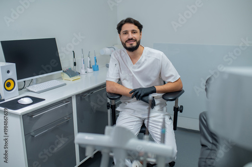 Fotografía Dark-haired young dentist in his office looking confident and busy
