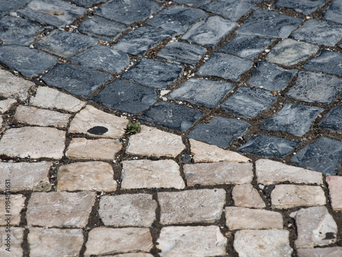 Traditional Portuguese Pavement Wave Pattern - Close-up abstract view of the iconic Calçada Portuguesa cobblestone pavement with a black and white wavy design.