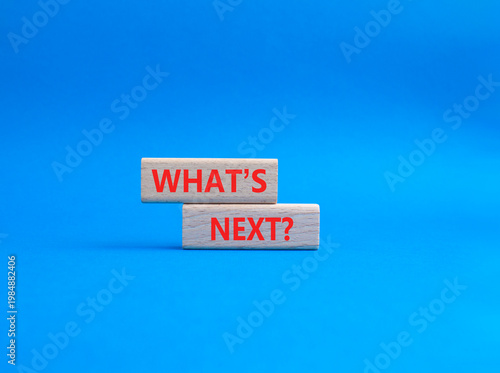 What is next symbol. Concept words What is next on wooden blocks. Beautiful blue background. Business and What is next concept. Copy space.